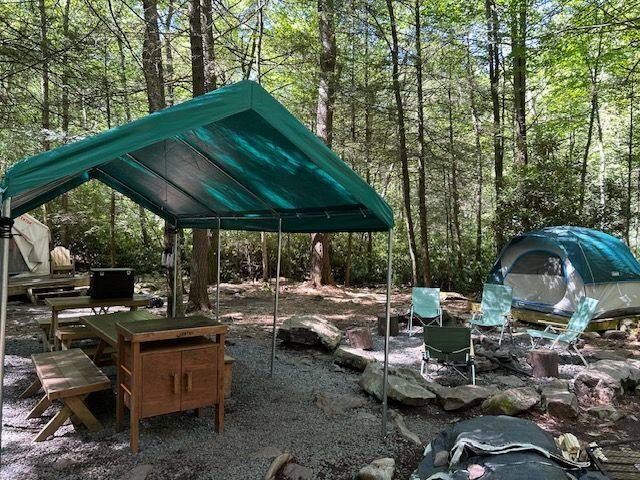 Covered dining area and a dome tent beside the creek